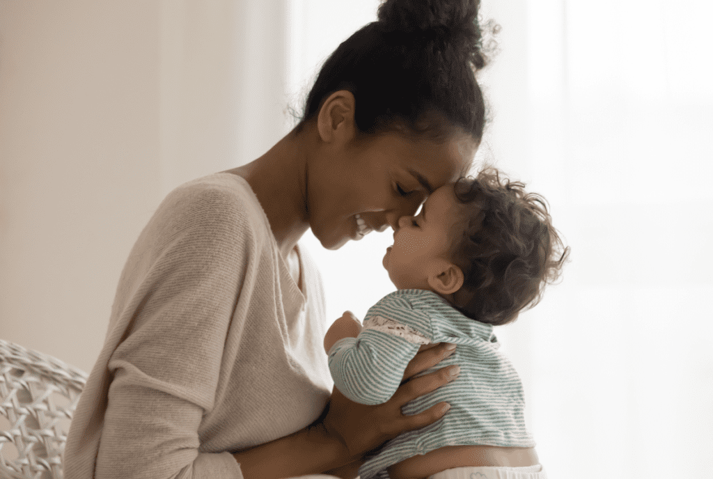 Young mom and child placing foreheads against one another